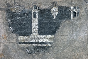 Lacerto di mosaico pavimentale con raffigurazione di mura e torri.